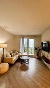 Una sala de estar con un sofá y un televisor. en Altura Apartment Arlington, en Arlington