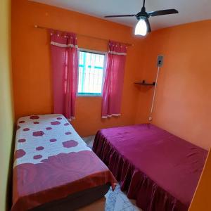 a bedroom with two beds and a ceiling fan at Refúgio da Paz - Itanhaém in Itanhaém