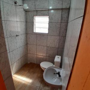 a small bathroom with a toilet and a sink at Refúgio da Paz - Itanhaém in Itanhaém +3 photos