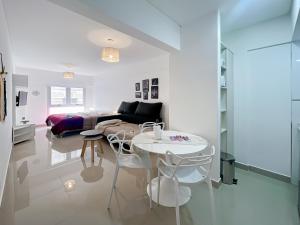 ein weißes Wohnzimmer mit einem Bett und einem Tisch in der Unterkunft Ayres Suites Moreno in Buenos Aires