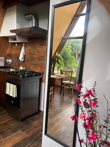 a kitchen with a view of a kitchen with a table at Cabaña del Campo in Santa Rosa de Copán