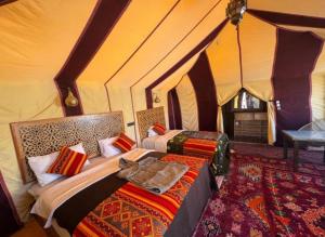 a bedroom with two beds in a tent at Great Luxury Camp in Merzouga