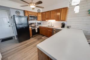 Una cocina con refrigerador negro y gabinetes de madera. en North Myrtle's Kings View, 2nd Floor, Great Views!, en Myrtle Beach