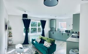 a kitchen with blue cabinets and a green couch at Dover Castle Views, private terrace and on-site parking in Dover