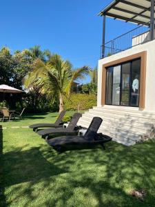 a row of lounge chairs sitting in the grass at Casa GOGA in Oaxtepec