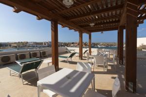 un patio avec des tables et des chaises blanches sur le toit dans l'établissement Silvia Affittacamere, à Lampedusa