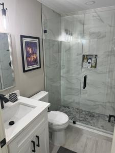 ein Badezimmer mit Dusche, Toilette und Waschbecken in der Unterkunft Brand NEW Renovated Coastal Beach House in Naples + 32 Fotos