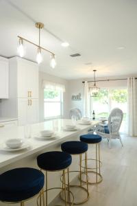 eine Küche mit weißen Arbeitsflächen und blauen Stühlen in der Unterkunft Brand NEW Renovated Coastal Beach House in Naples
