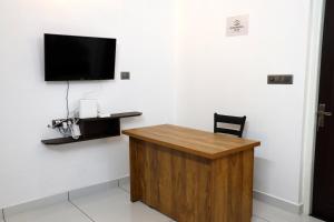 a room with a desk and a tv on a wall at Chooravelil Villa, Adimali - Family Stay Near Munnar in Anniyartholu