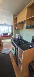 eine Küche mit Herd und Herd oberen Backofen in der Unterkunft Lyons Winkups Holiday Park Towyn, North Wales static Caravan 3 bedroom sleeps 8 free entertainment in Kinmel Bay
