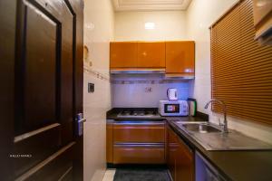 Una pequeña cocina con fregadero y microondas. en East Legon Luxury Stay - AC, Wifi, Netflix, en Accra