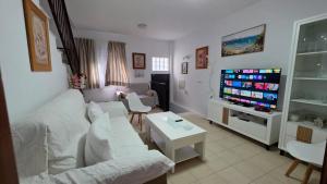 a living room with a couch and a flat screen tv at Dúplex con solárium privado junto al Ayuntamiento de Barbate in Barbate
