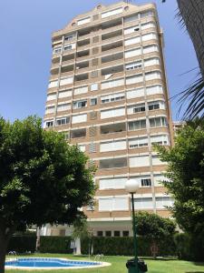 un edificio alto con un parque delante de él en Monver 10, en Benidorm