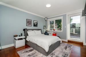 a bedroom with a large bed and two windows at World Cup Coastal Getaway in White Rock