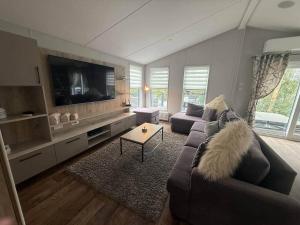 a living room with a couch and a flat screen tv at Sunset Bay in Tattershall