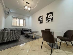 贝尼迈拉勒Dana的客厅里有一张沙发、一张桌子和几把椅子。