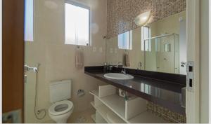 a bathroom with a toilet and a sink and a mirror at Casa Praia em João Pessoa Praia de Camboinha Cabedelo in Cabedelo +9 photos