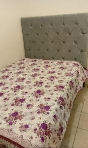 1 cama con edredón de flores en un dormitorio en Casa Victoria, en Gómez Palacio