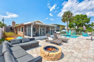 a patio with couches and a fire pit in front of a house at Hernando Beach Gulf Access, Dock & Heated Pool in Hernando Beach