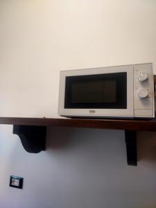 a microwave sitting on top of a wooden shelf at Casa di Doria in Deiva Marina