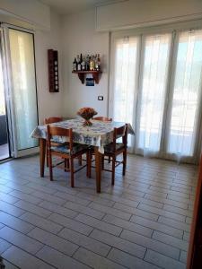 a dining room with a table and chairs and windows at Casa di Doria in Deiva Marina