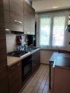 a kitchen with wooden cabinets and a stove top oven at Casa di Doria in Deiva Marina