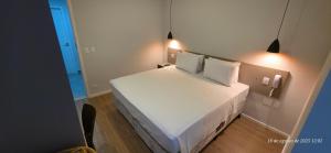 a bedroom with a large white bed with two pillows at Jaguaré Hotel in São Paulo