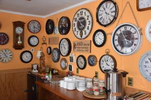 a room filled with clocks on the wall at Asói Hostal in Puerto Natales