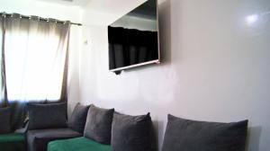 a living room with a couch and a tv on the wall at City Center Stay - Résidence Omar 1 by ZenStay in Fès