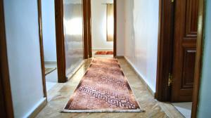 a hallway with a brown rug on the floor at City Center Stay - Résidence Omar 1 by ZenStay in Fès