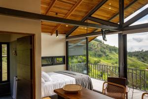 a bedroom with a bed and a balcony with a view at BiBO Casa Savia in Monteverde Costa Rica