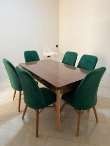 a wooden table with green chairs in a room at Apartment in downtown Fez in Fès