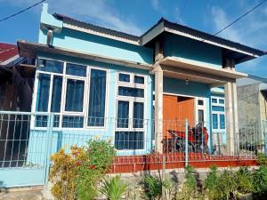 a blue and white house with a fence at Chinta Khanza 