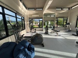 una palestra con diversi tapis roulant e macchine in una stanza di The Golden Palm Residence - Kathu - 10 min to Patong Beach a Ban Thung Thong