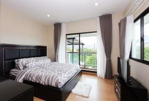 una camera da letto con un letto e una grande finestra di The Golden Palm Residence - Kathu - 10 min to Patong Beach a Ban Thung Thong Altre 44 foto