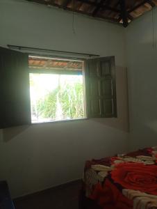 a room with a window and a bed in it at Quarto Pé na Areia in Ilhéus