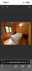 a small bedroom with a bed in a wooden room at Cabanas Gael in Mar de las Pampas