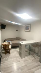 a room with a bed and a desk and a table at Terra Loft in El Chalten