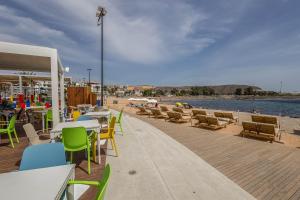 a patio with tables and chairs and a beach at Apartamentos L O L A Arguineguin in Arguineguín