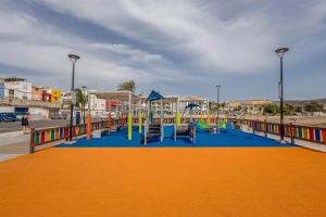 a playground with colorful playground equipment on a street at Apartamentos L O L A Arguineguin in Arguineguín
