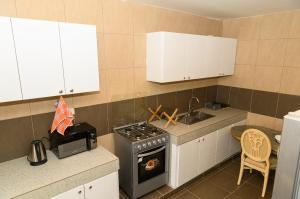 a small kitchen with a stove and a sink at Chambre double lumineuse in Dakar
