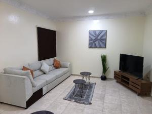 ダンマームにあるAl Qurashi Residences Al Faiha Dammamのソファとテレビのあるリビングルーム