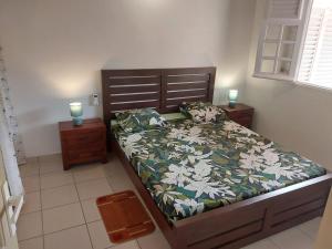 a bed in a bedroom with two candles on two tables at Tiatia T3 in Les Anses-dʼArlets