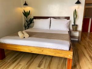a bed with white sheets and pillows in a room at Appartment Bonak peaceful Beachfront Escape with Kitchen and AC in General Luna