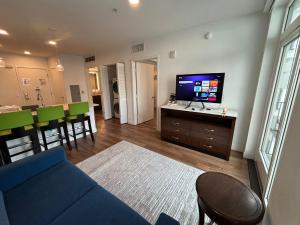 un salon avec un canapé bleu et une télévision à écran plat dans l'établissement Glamorous KTown Boutique Residences with Rooftop view, à Los Angeles