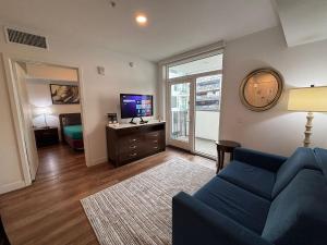 a living room with a blue couch and a tv at Glamorous KTown Boutique Residences with Rooftop view in Los Angeles
