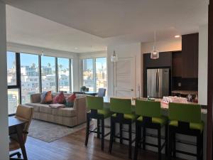 una cucina e un soggiorno con sedie da bar verdi di Glamorous KTown Boutique Residences with Rooftop view a Los Angeles
