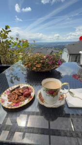 a table with a cup of coffee and a plate of food at Carrie The Gentle Nest 1 in Coquitlam