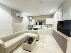 a living room with a couch and a kitchen at فندق ضيافة المدينة in Medina