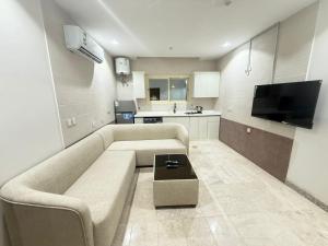 a living room with a couch and a tv at فندق ضيافة المدينة in Medina